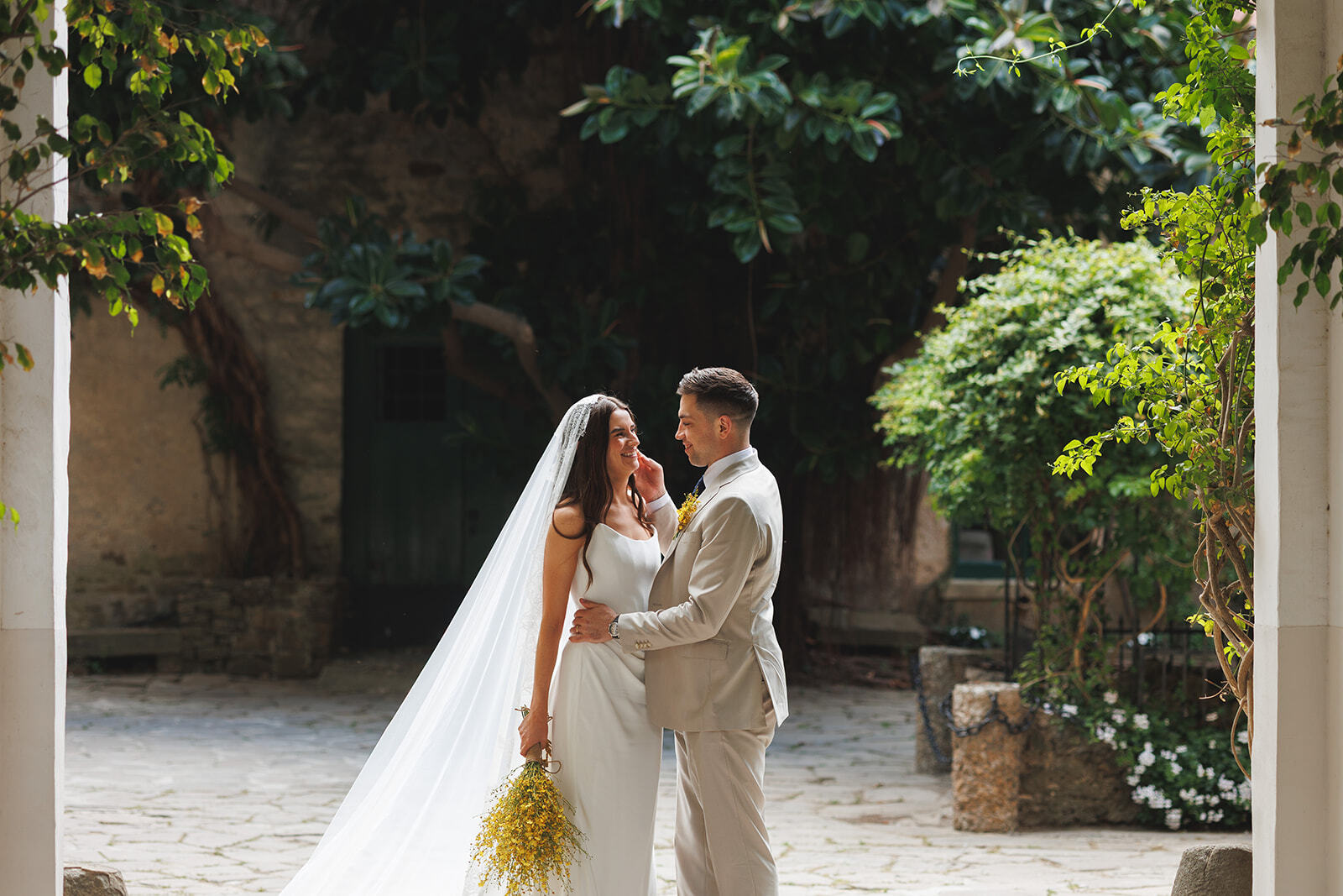 Kathy e Alex uno di fronte all’altra in un cortile verde di Palazzo Belmonte.