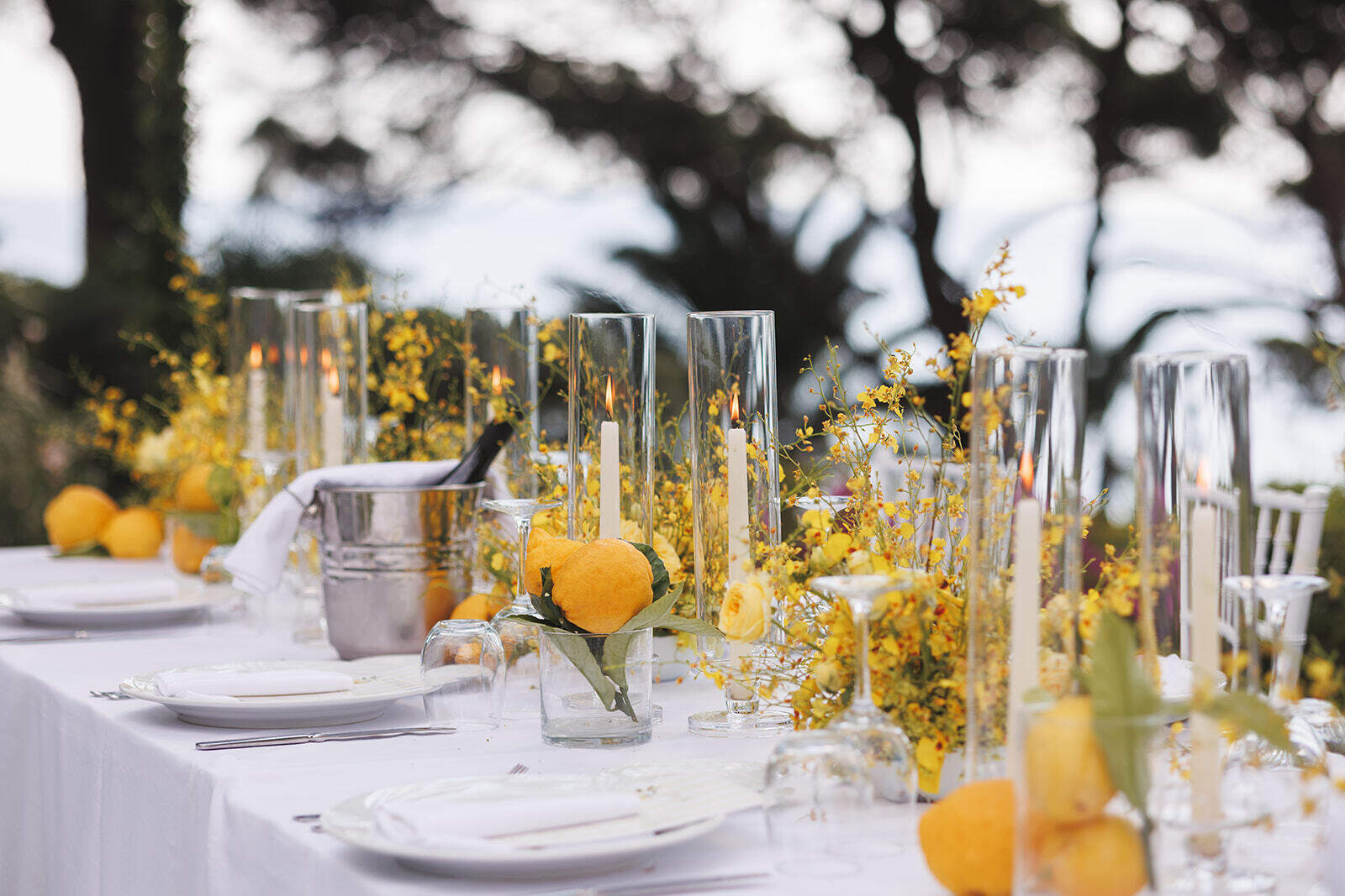 Tavola del matrimonio con fiori gialli, limoni e portacandele in vetro a Palazzo Belmonte.